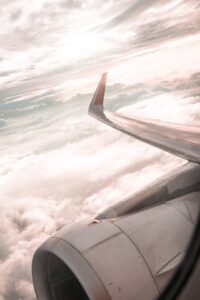 Pilot's aerial view of clouds and plane wing, engine